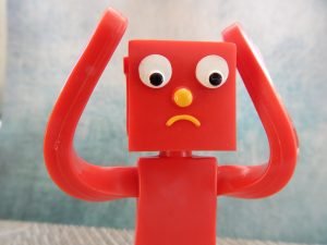 Image of a red Gumby figure with its arms up with a confused look on its face